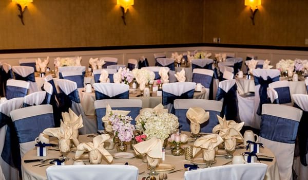 Wedding reception area with blue ribbon around chairs