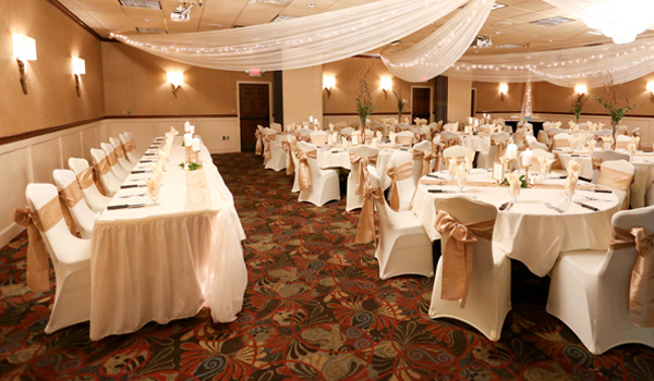Wedding reception area with gold ribbon around chairs