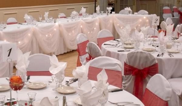 Wedding reception area with red ribbon around chairs