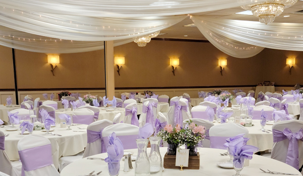 Wedding reception area with red table cloths and red ribbon around chairs